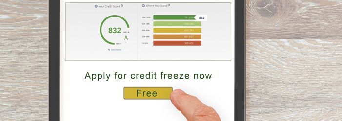 A person is pressing a button on a cell phone to apply for credit freeze now.