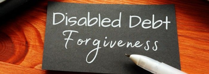 A person is writing on a piece of paper that says disabled debt forgiveness.