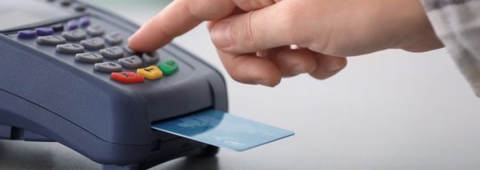 A person is inserting a credit card into a credit card reader emphasizing the advantage of using a credit card.