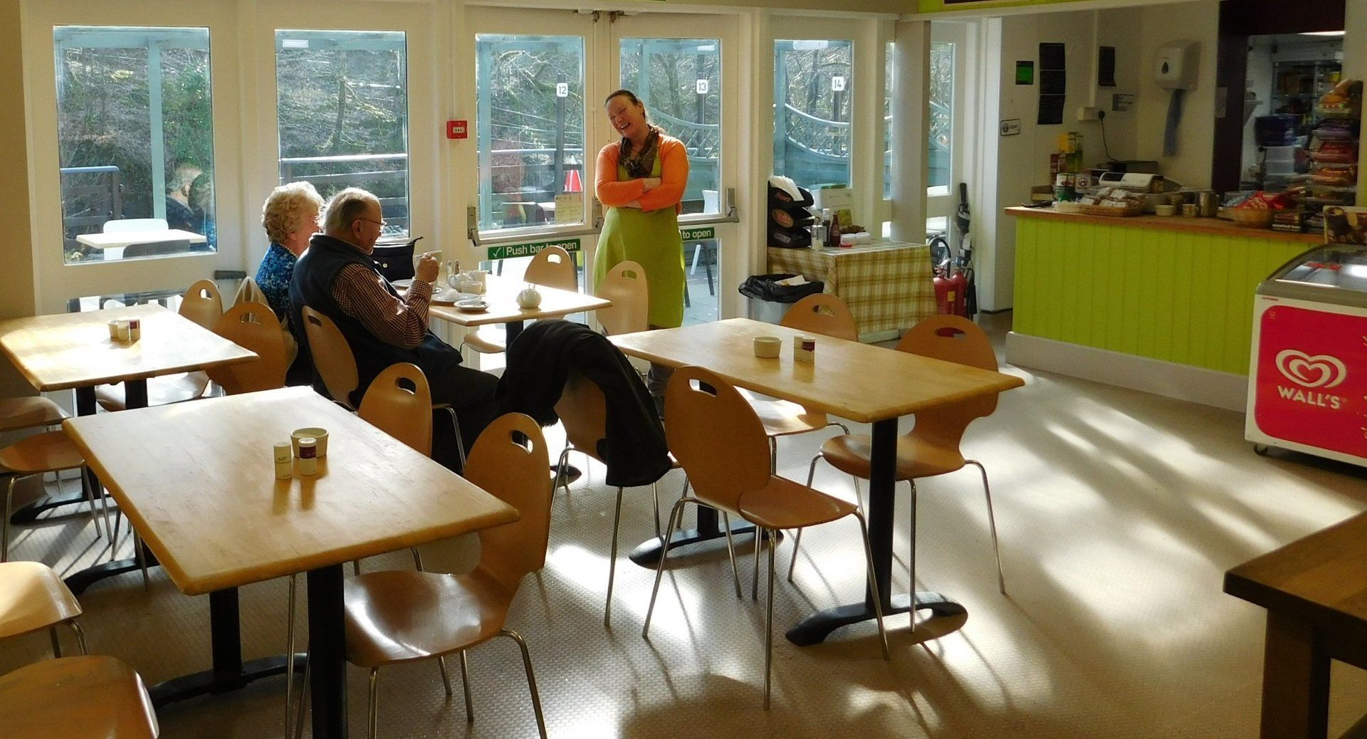 Photo of the on site cafe. 3 tables with some people eating lunch