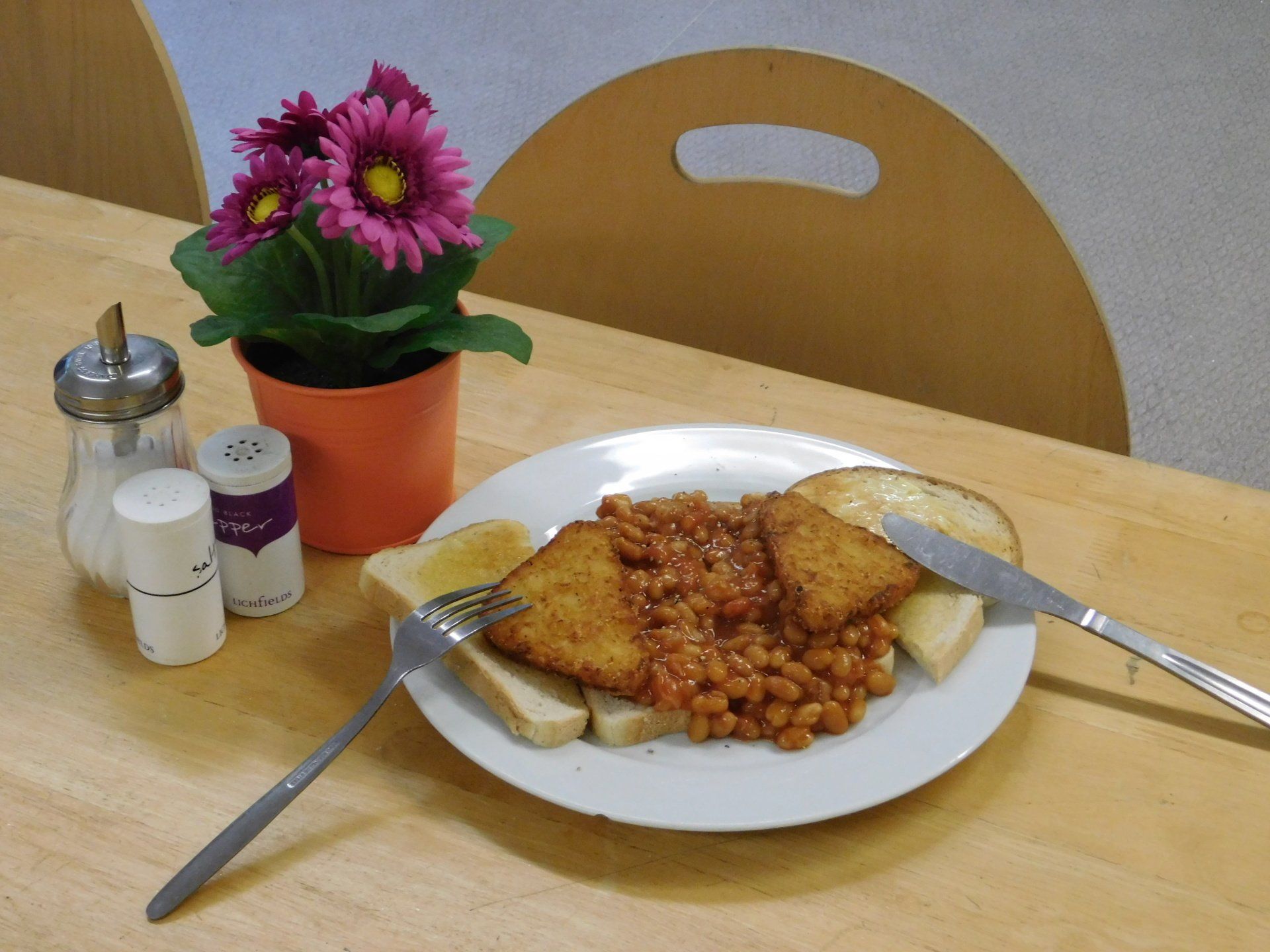 A breakfast of hash browns and baked beans on toast