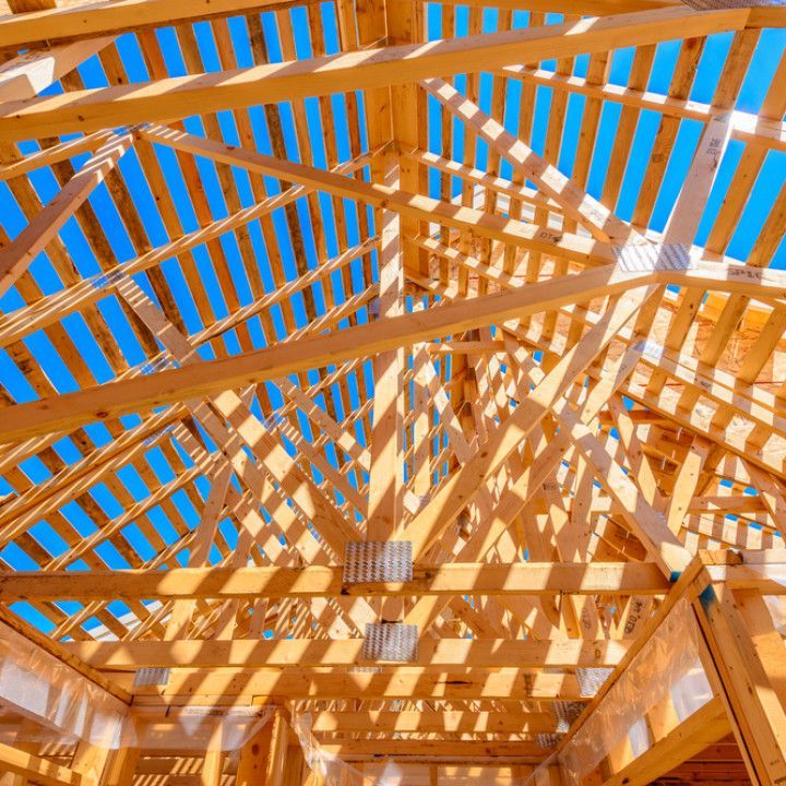 The ceiling of a building under construction with a blue sky in the background.
