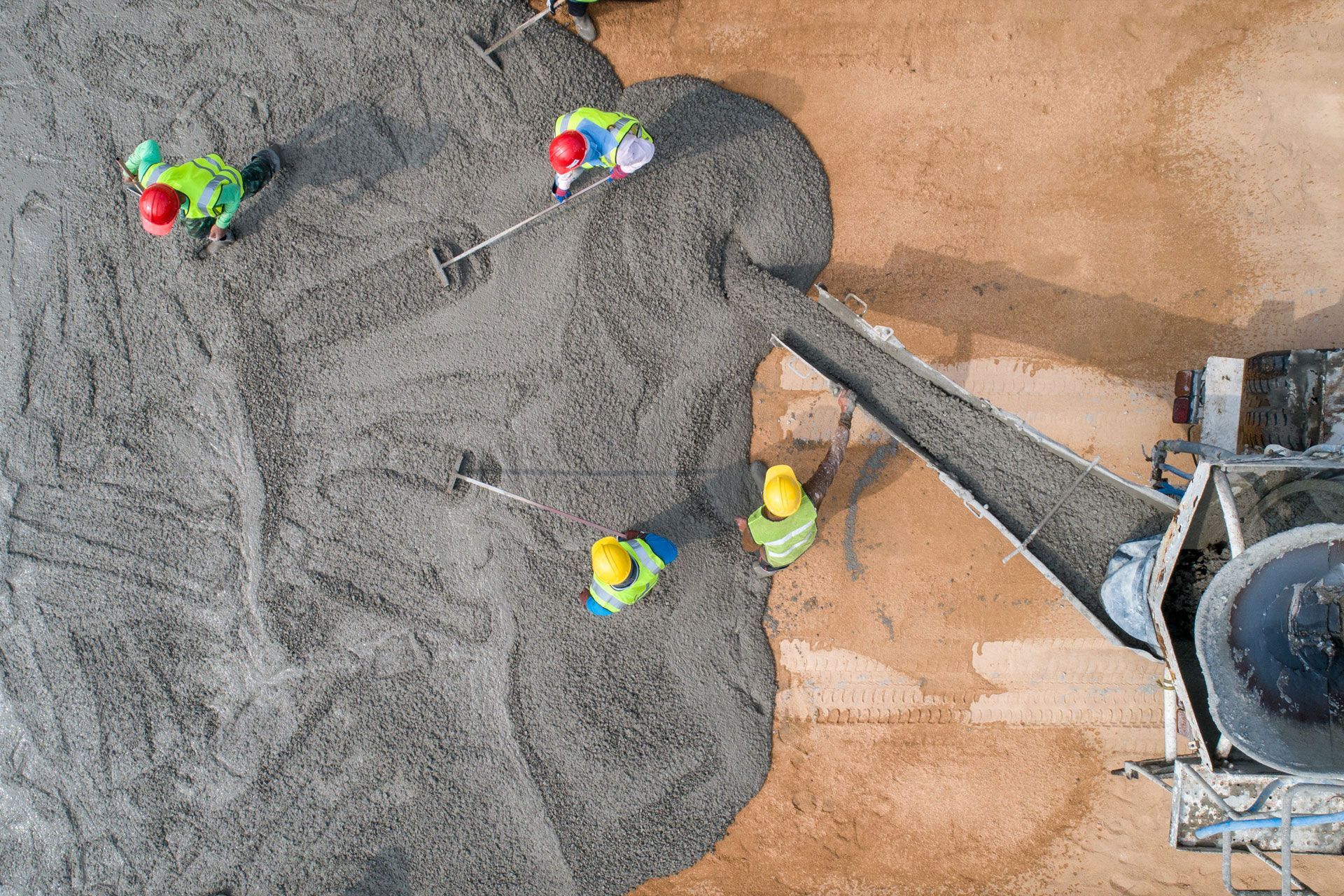 An aerial view of a group of construction workers pouring concrete.