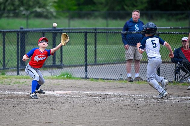 Baseball player sliding into home plate, catcher in front. Blue and gold uniforms, action shot.