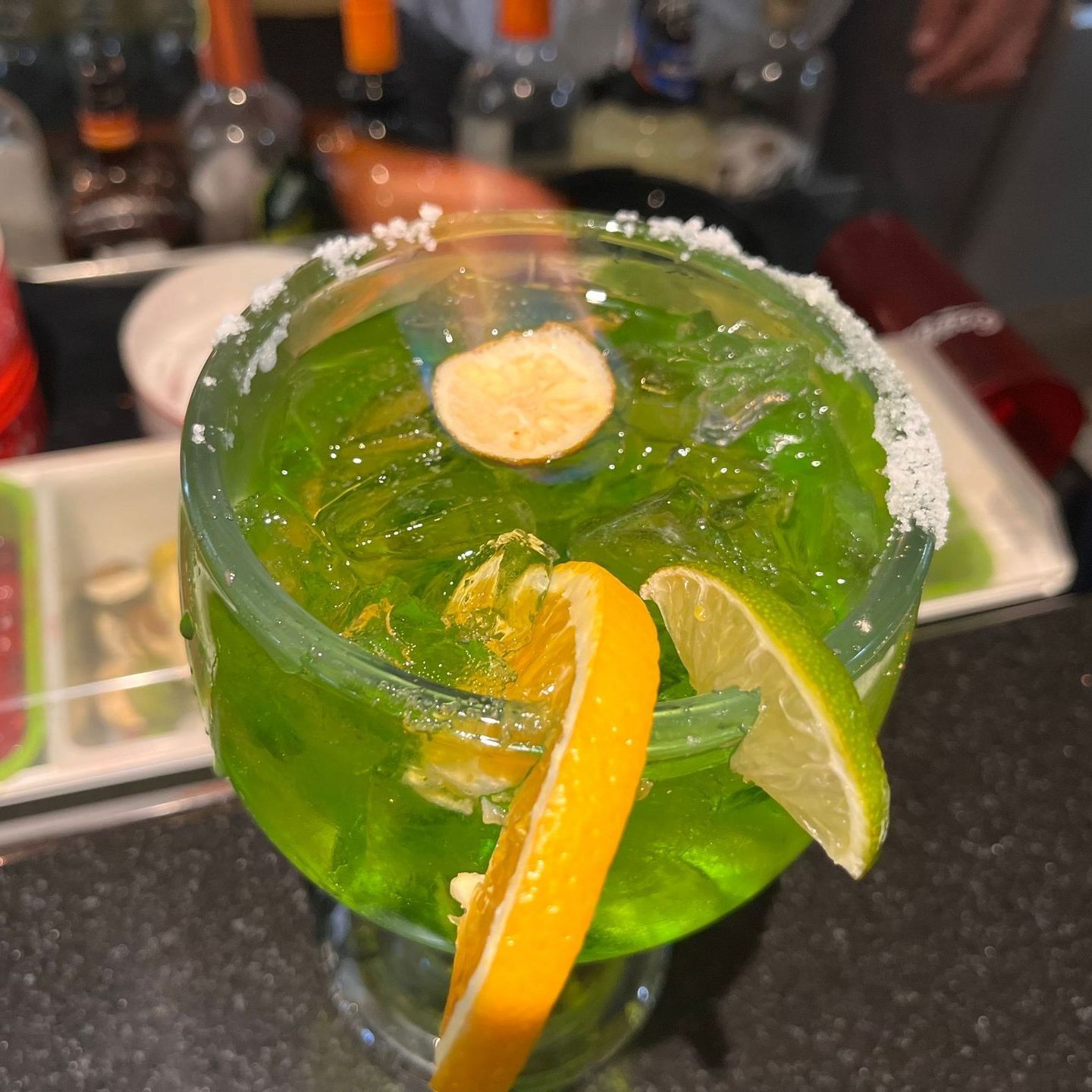 A green drink with a slice of orange in it