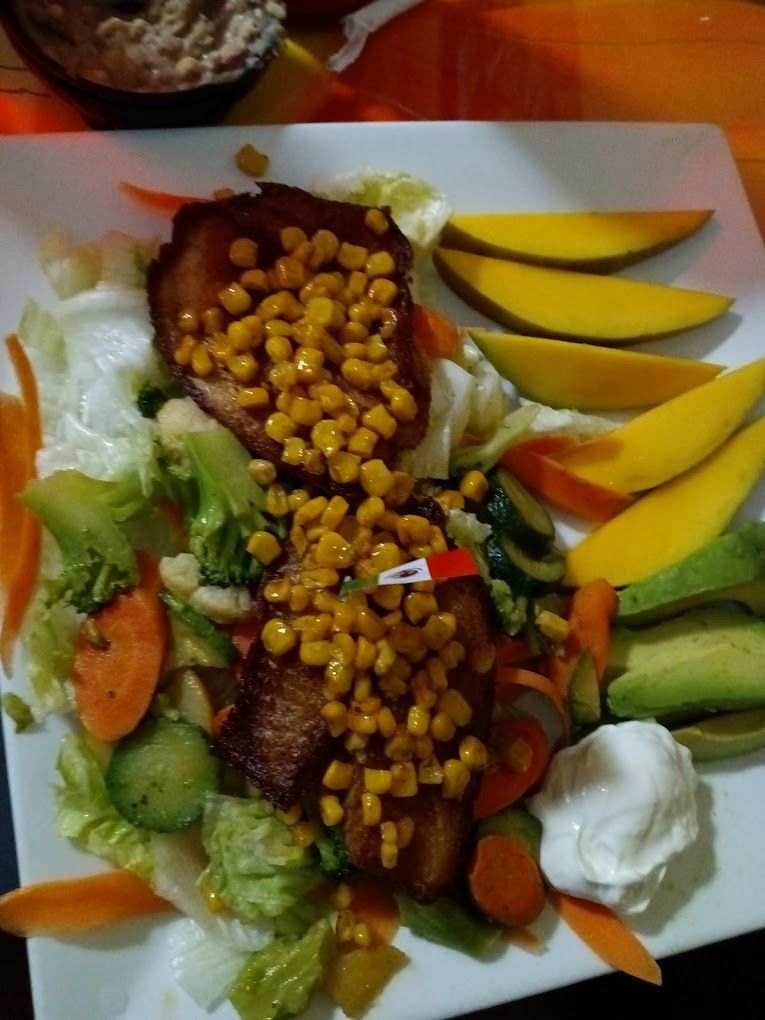 A plate of food with corn and mangoes on it