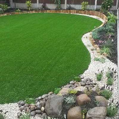 A bright green curved lawn surrounded by a neatly arranged pathway