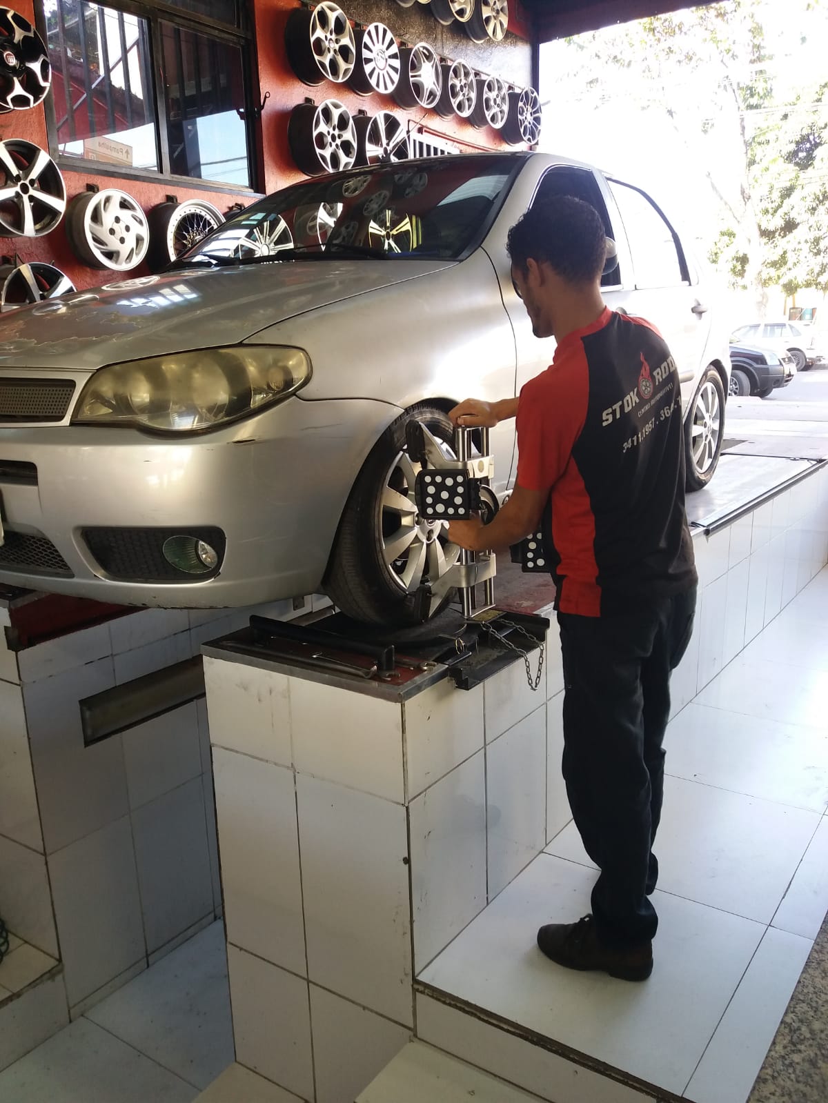 Um homem está trabalhando em um carro em uma garagem.