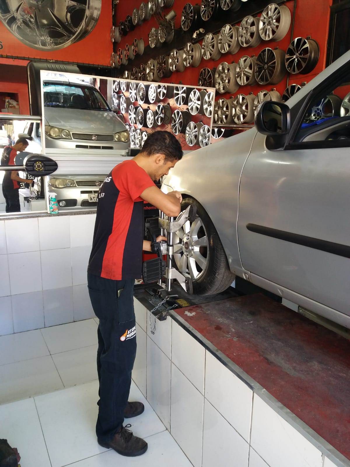 Um homem está trabalhando em uma roda de carro em uma garagem