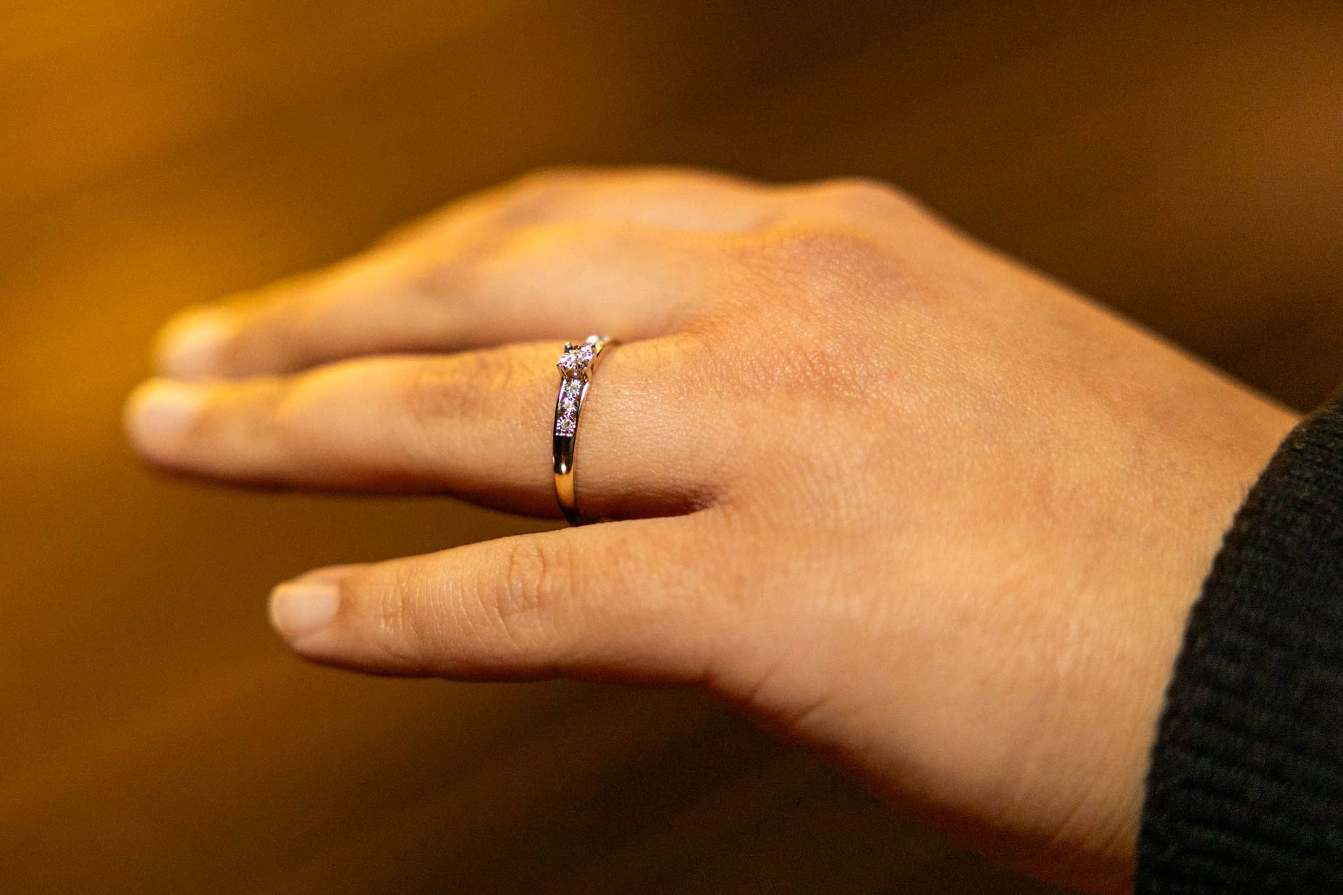 Hand met een ring om de vinger. De ring is bezet met kleine edelstenen.