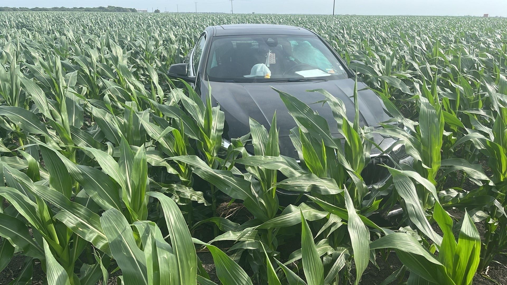 A silver car being towed by a tow truck from a handicapped parking space, worker in orange.