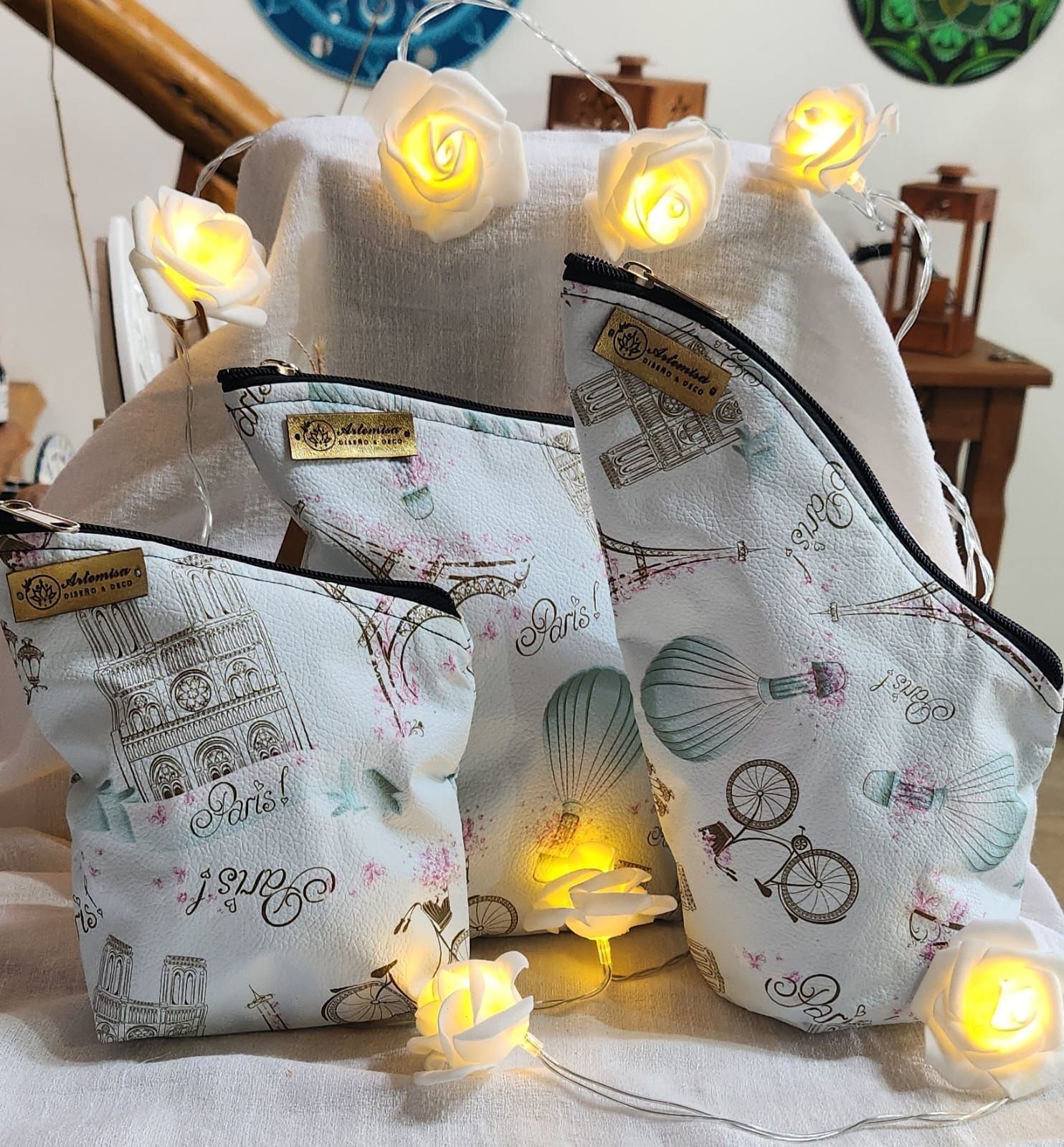 Tres neceseres con motivos parisinos, de diferentes tamaños, con luces de cuerda