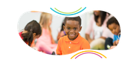 a young boy in an orange shirt is smiling in front of a group of children .