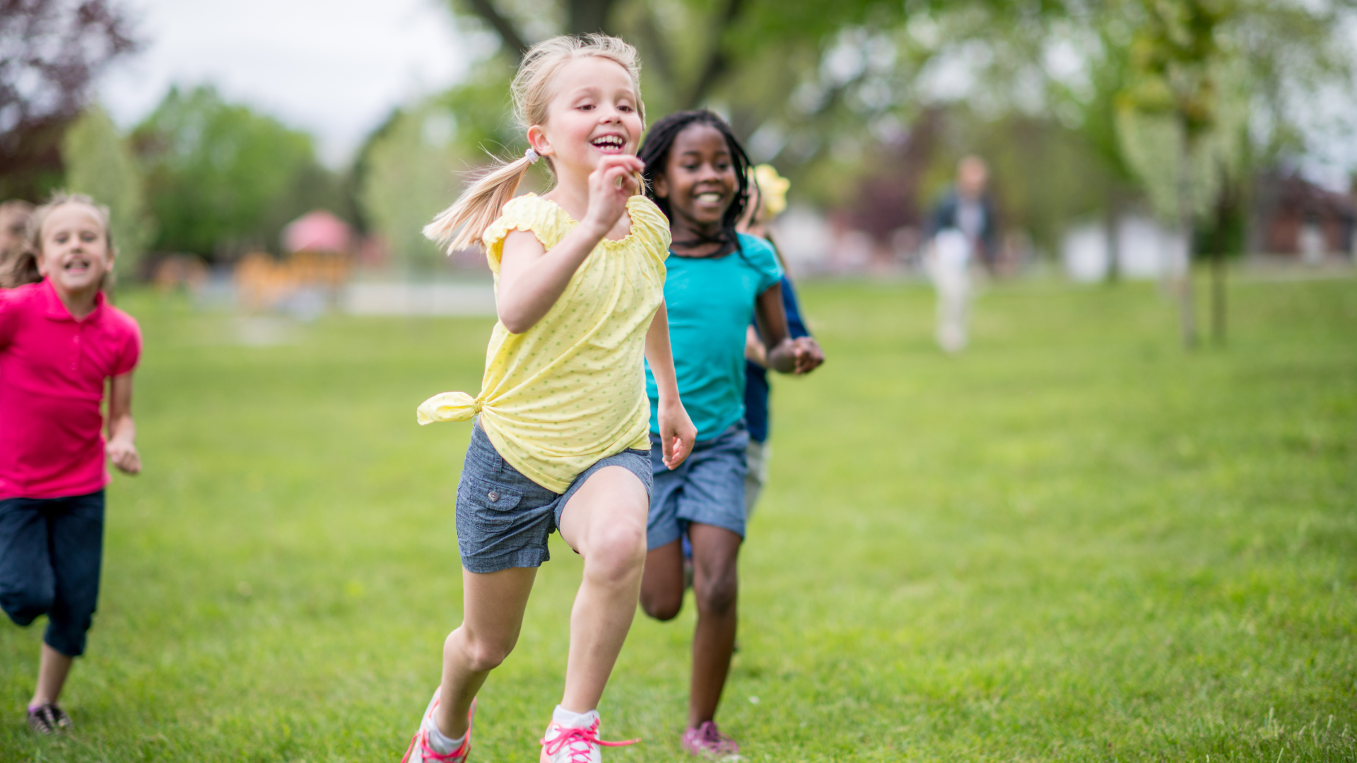 A group of young girls are running in a park.