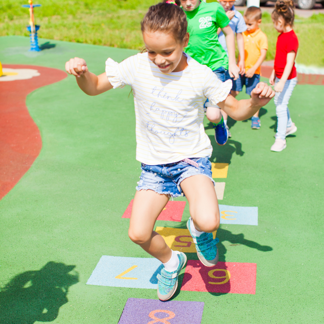 A group of children are playing hopscotch in a park