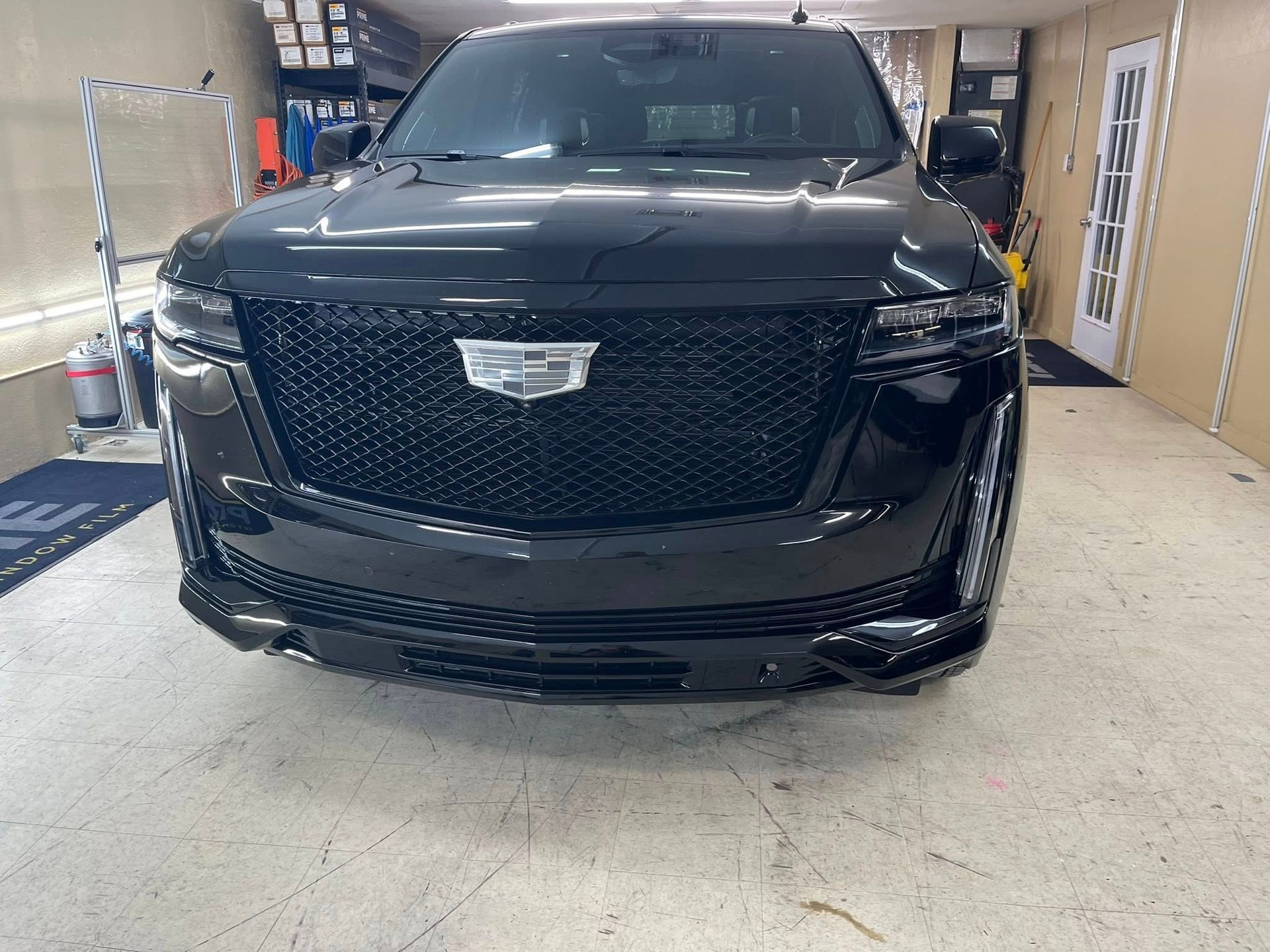 Black Cadillac Escalade parked inside a garage.