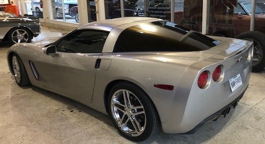 Silver Chevrolet Corvette coupe parked indoors.