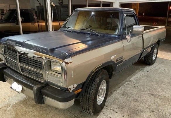 Two-tone blue and tan Dodge Ram pickup truck parked indoors under fluorescent lights.