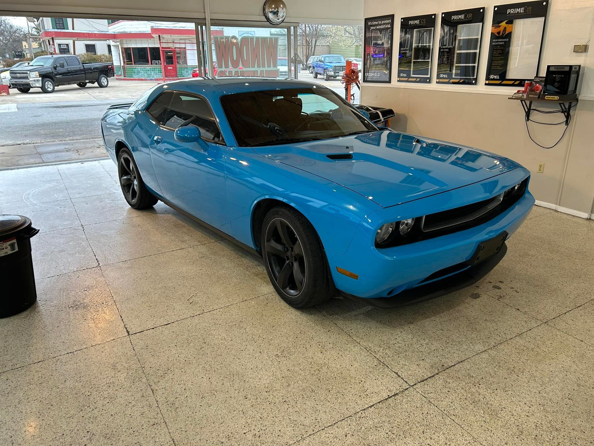 Bright blue Dodge Challenger in a garage.