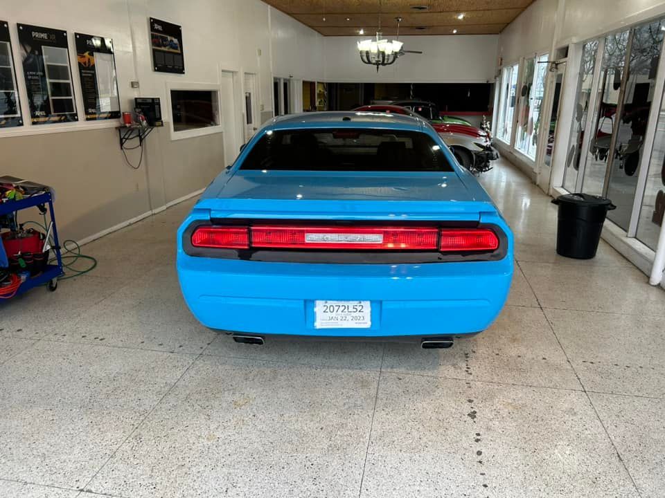 Blue Dodge Challenger in a garage.