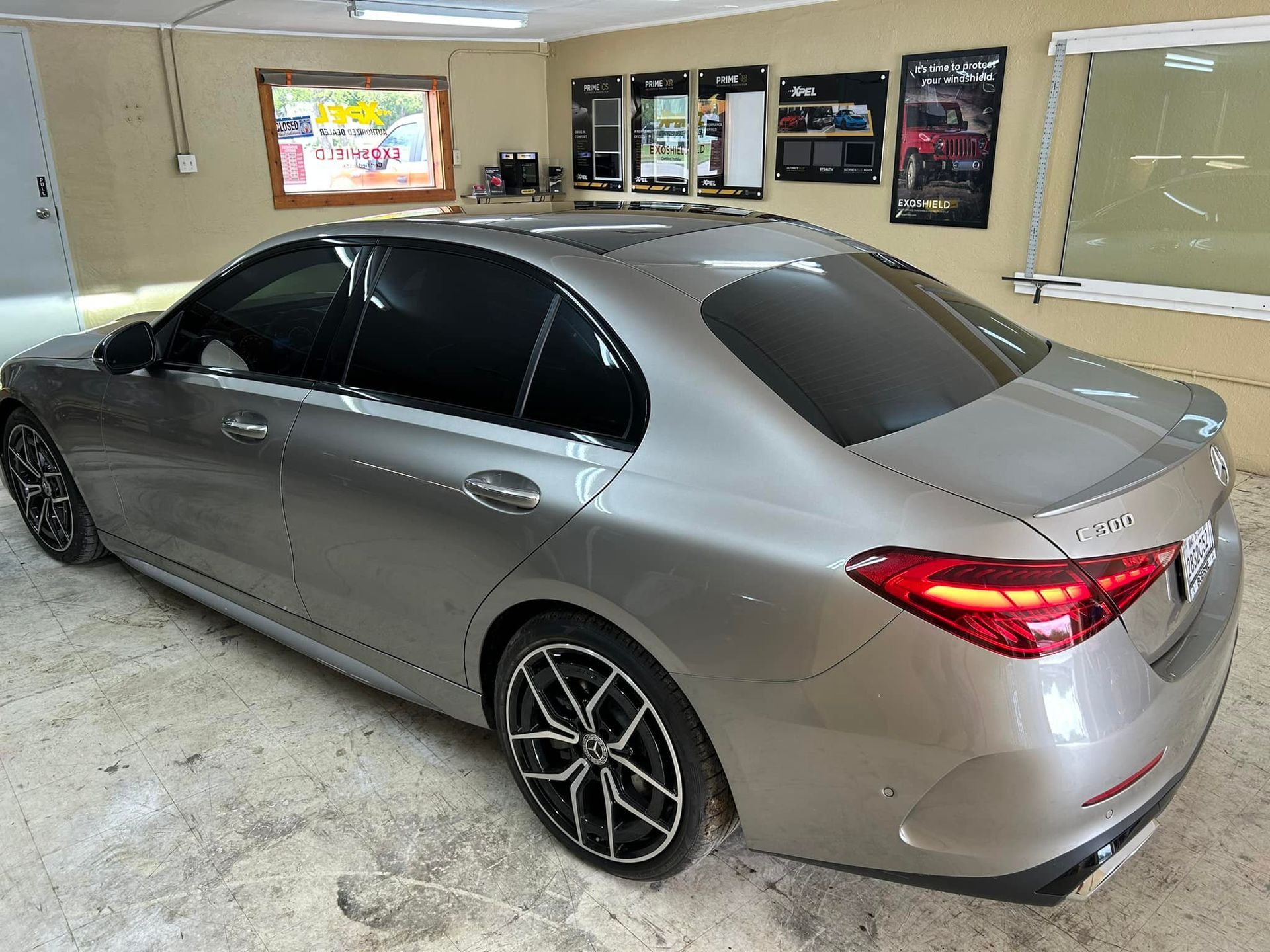 Silver sedan with tinted windows parked inside a shop.