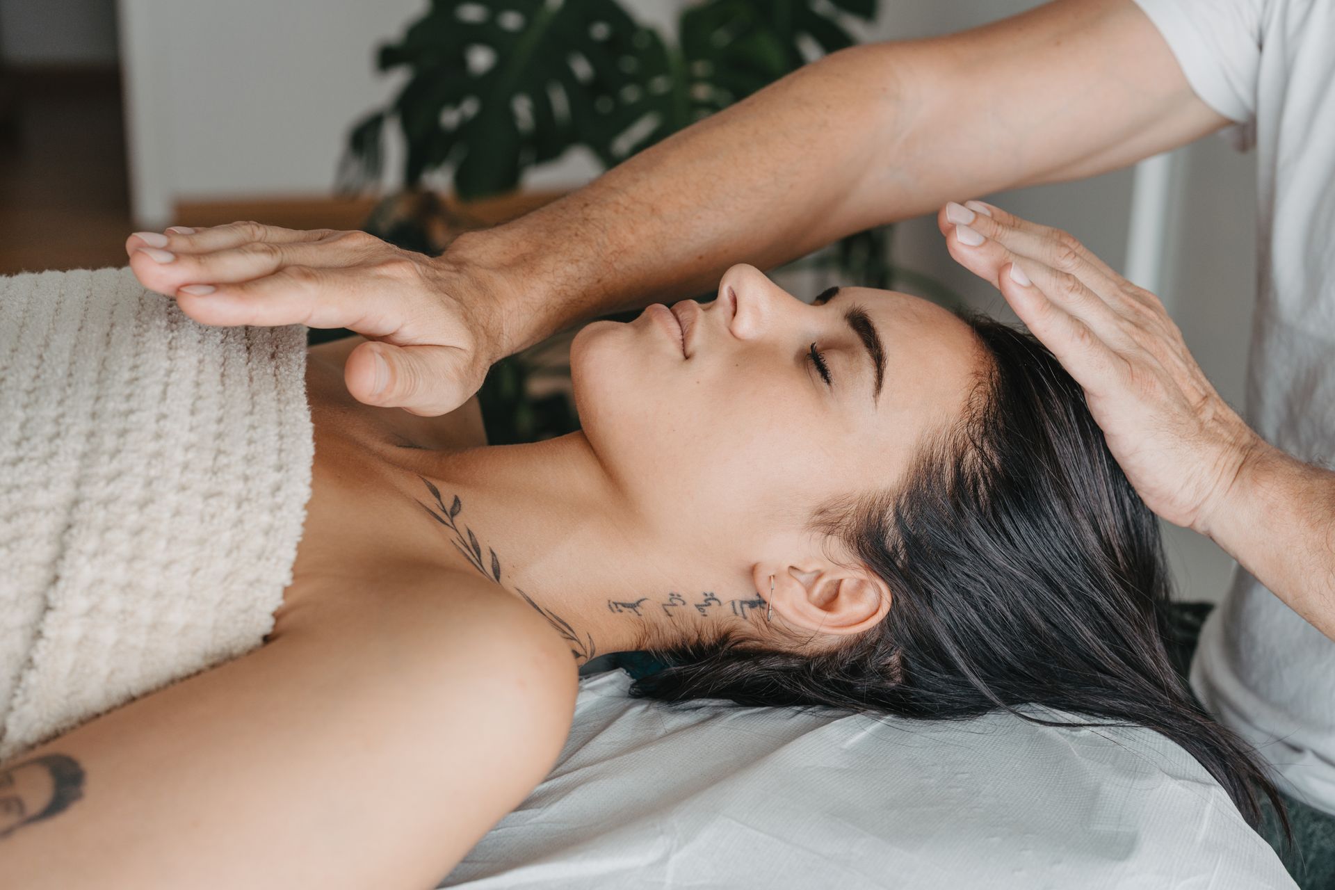 A woman is laying on a bed getting a massage from a man.