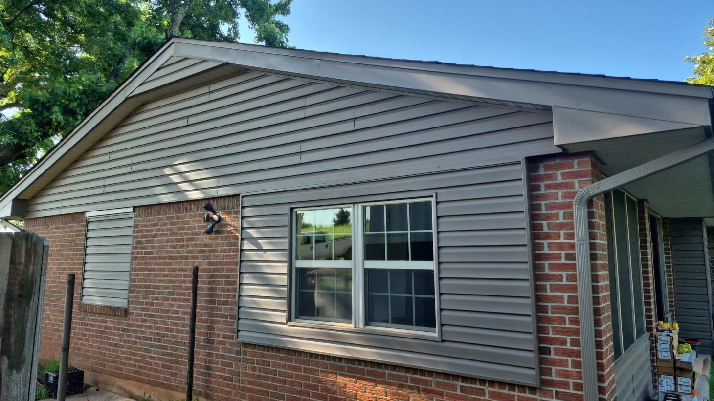 A brick building with two windows and a door missing