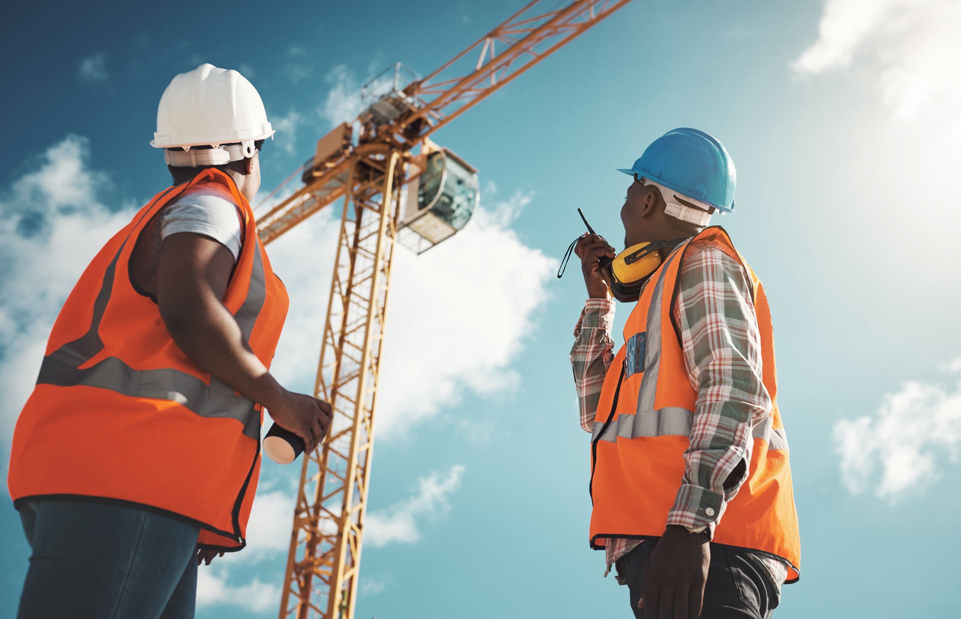 Two Inspectors Are Standing Next to a Crane on a Construction Site