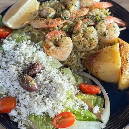 A plate of food with a gyro and a salad on a table.