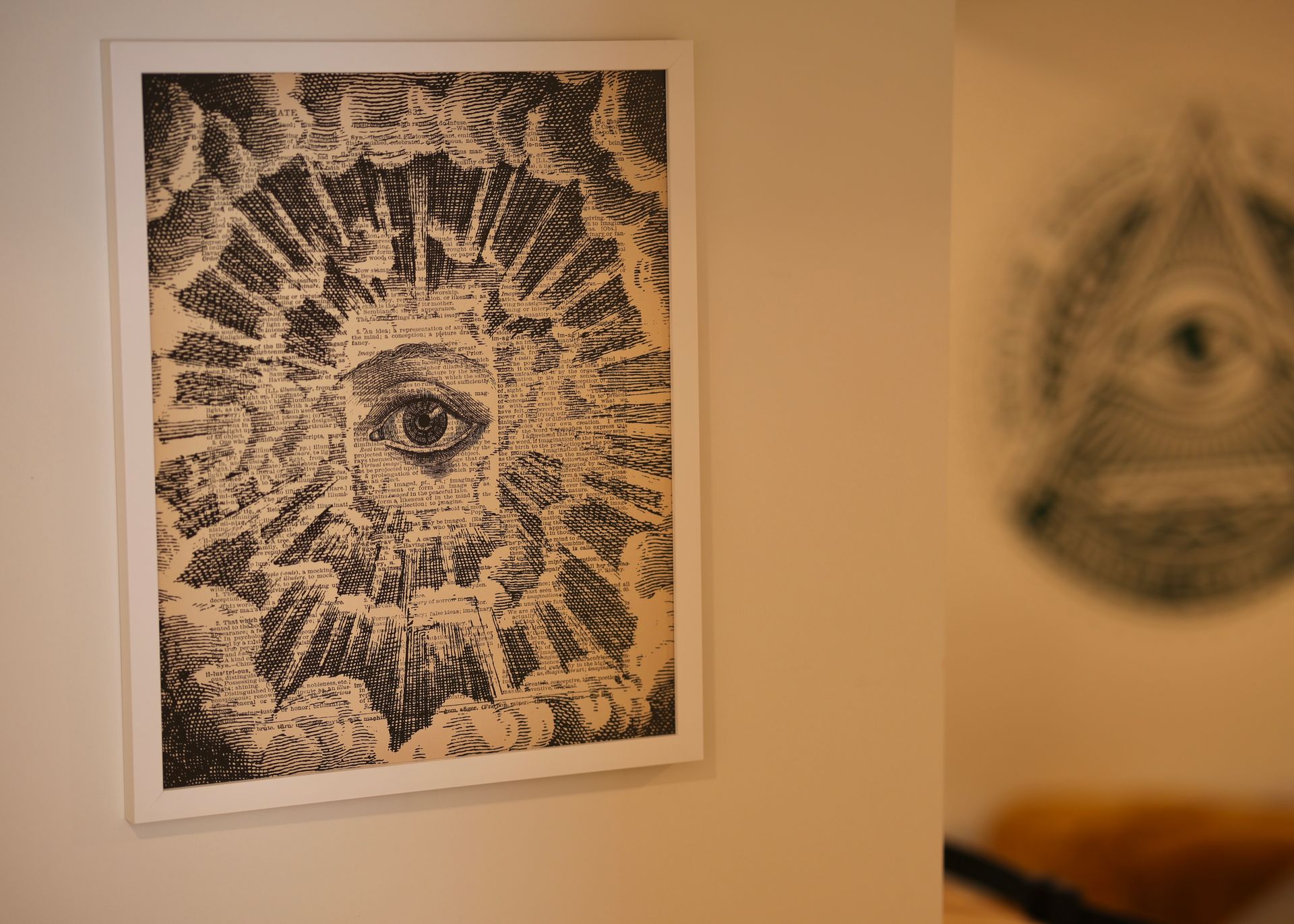 A painting of an all seeing eye is hanging on a wall