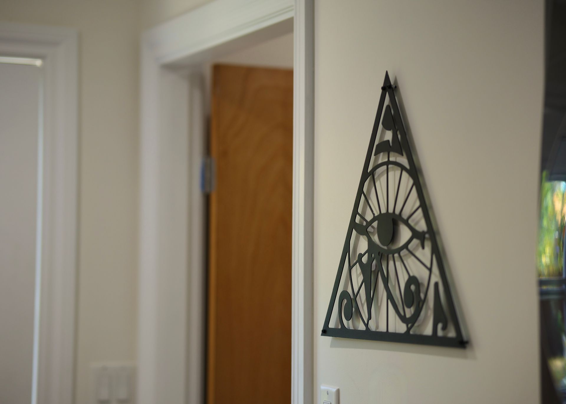 A triangle with an eye on it is hanging on a wall