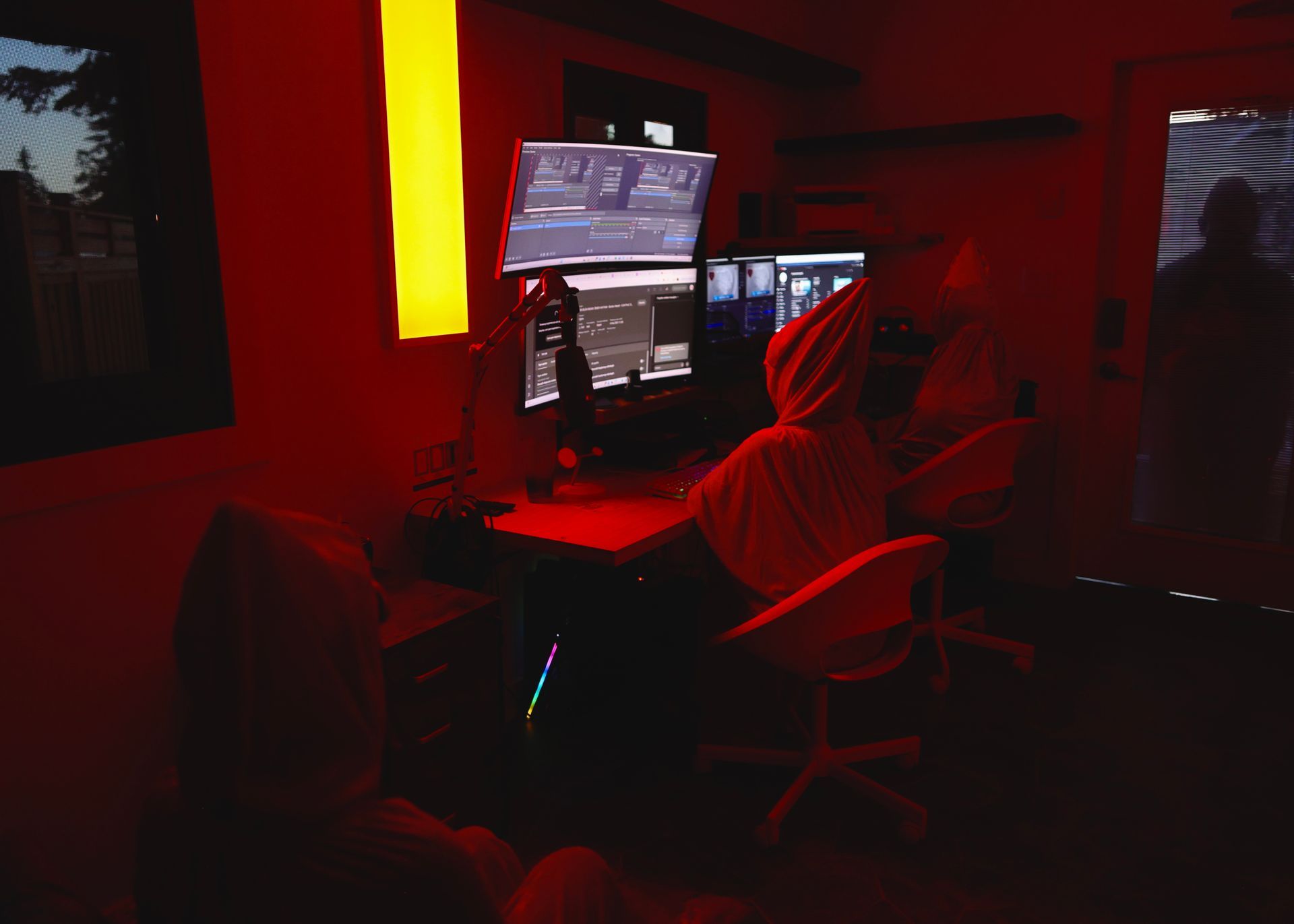 A person is sitting in front of a computer in a dark room.