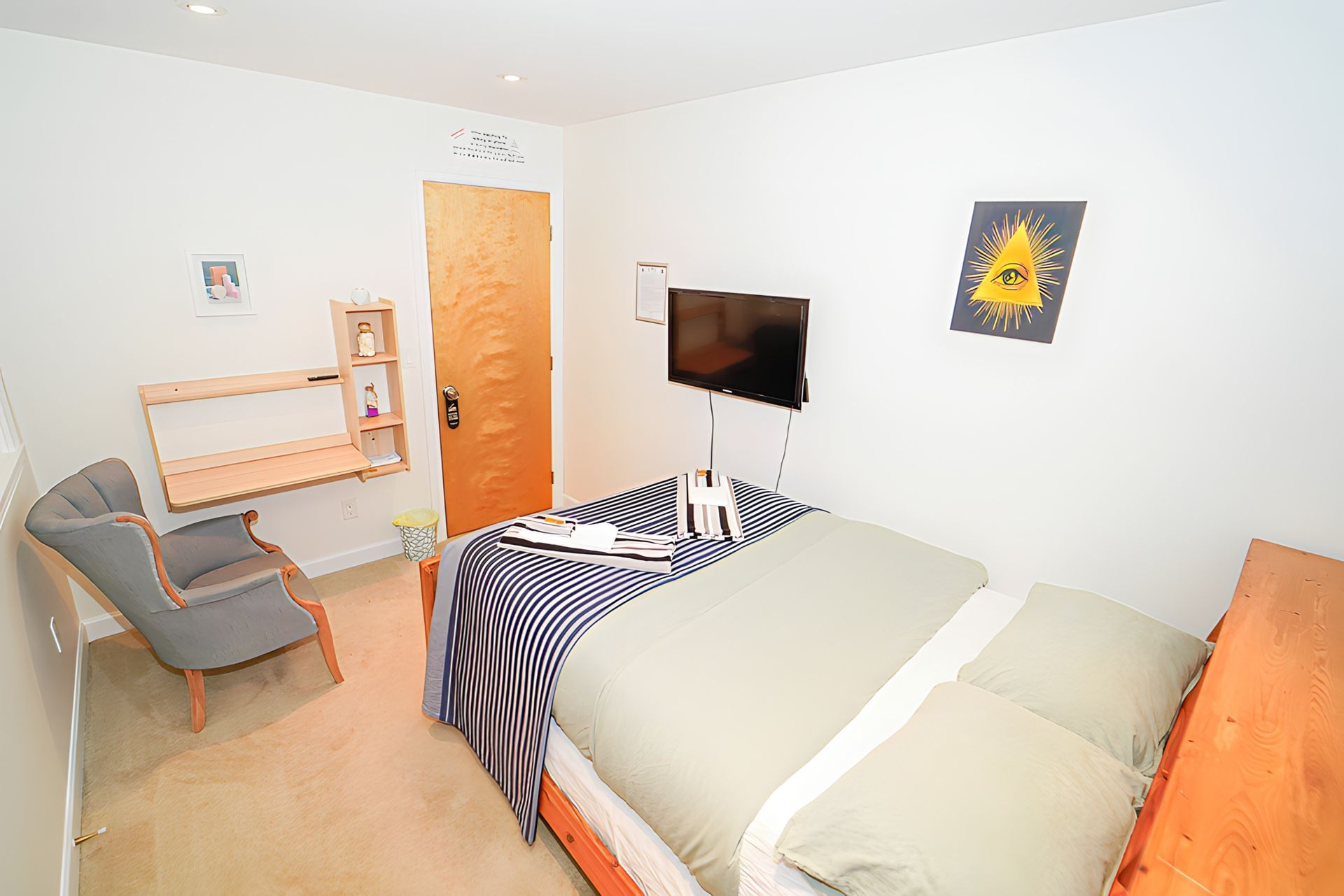 A bedroom with a bed , chair and television.