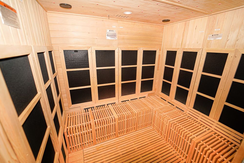 A wooden sauna with black windows and a wooden floor.