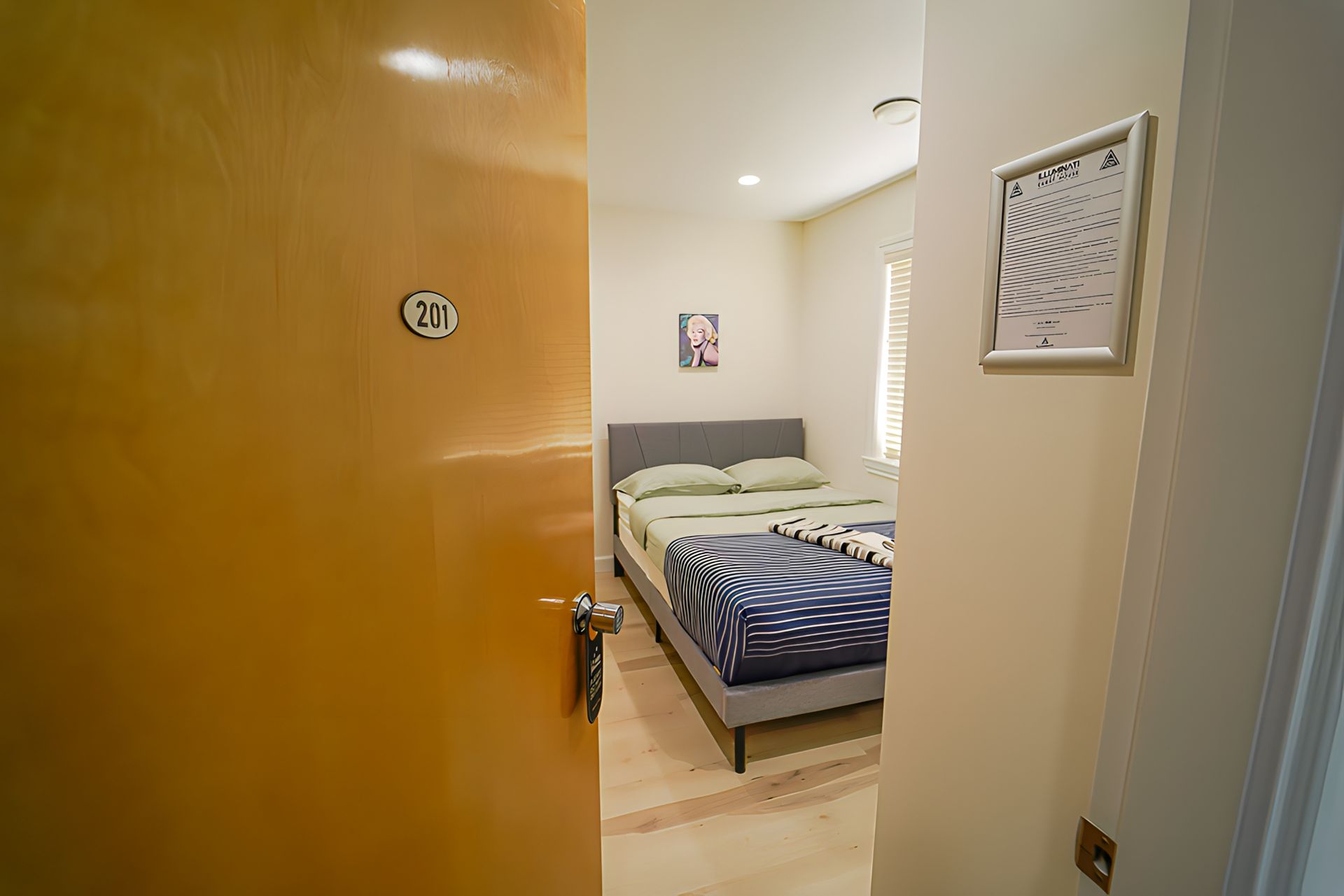 A bedroom with a bed and a door leading to it.