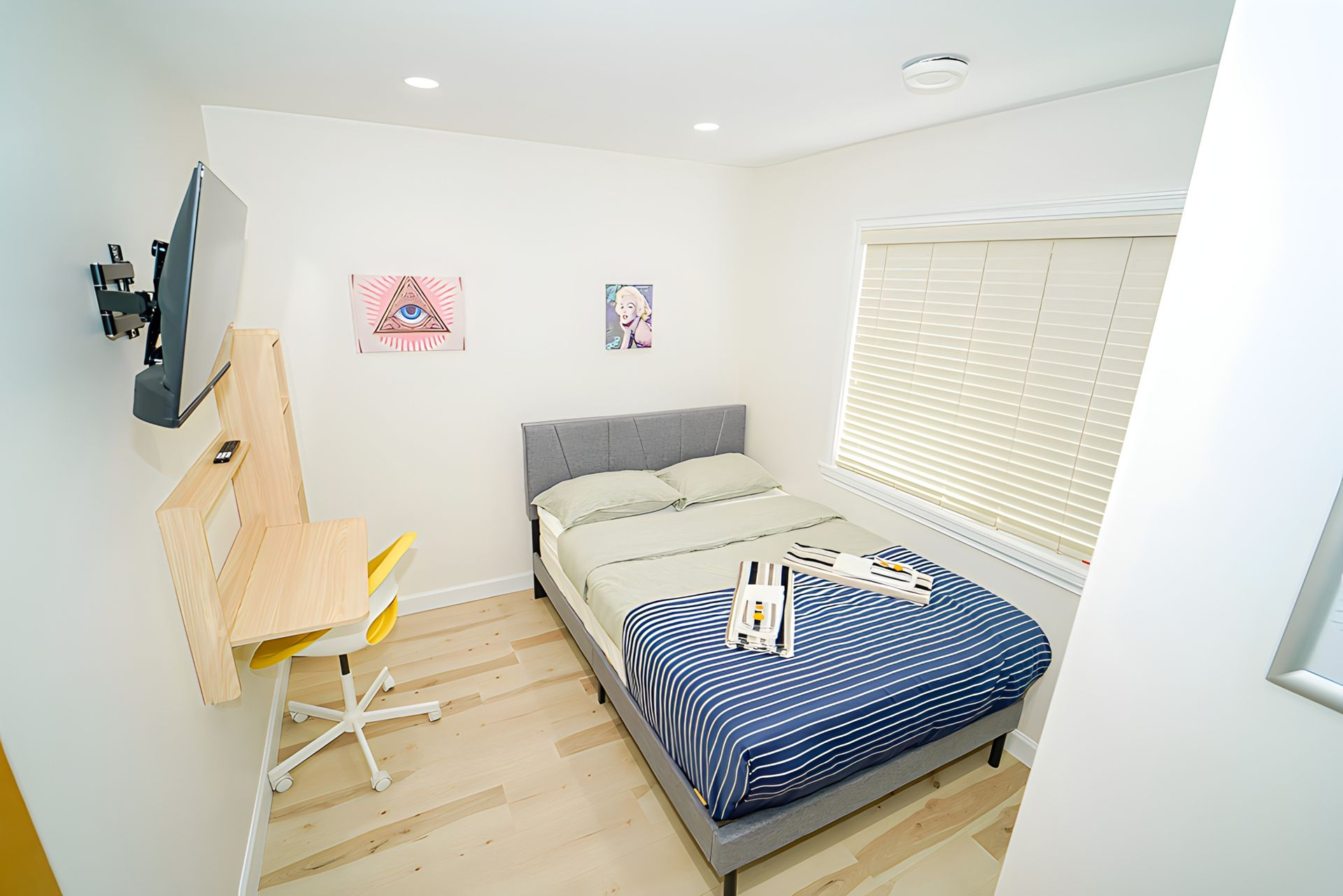 A bedroom with a bed , desk and television.