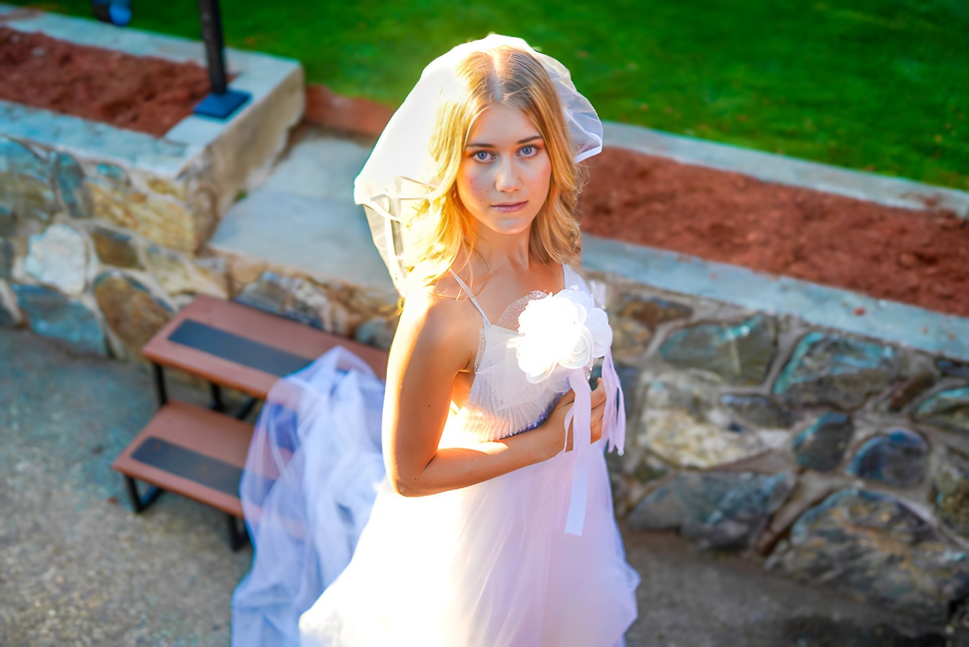 A woman in a wedding dress and veil is holding a bouquet of flowers.