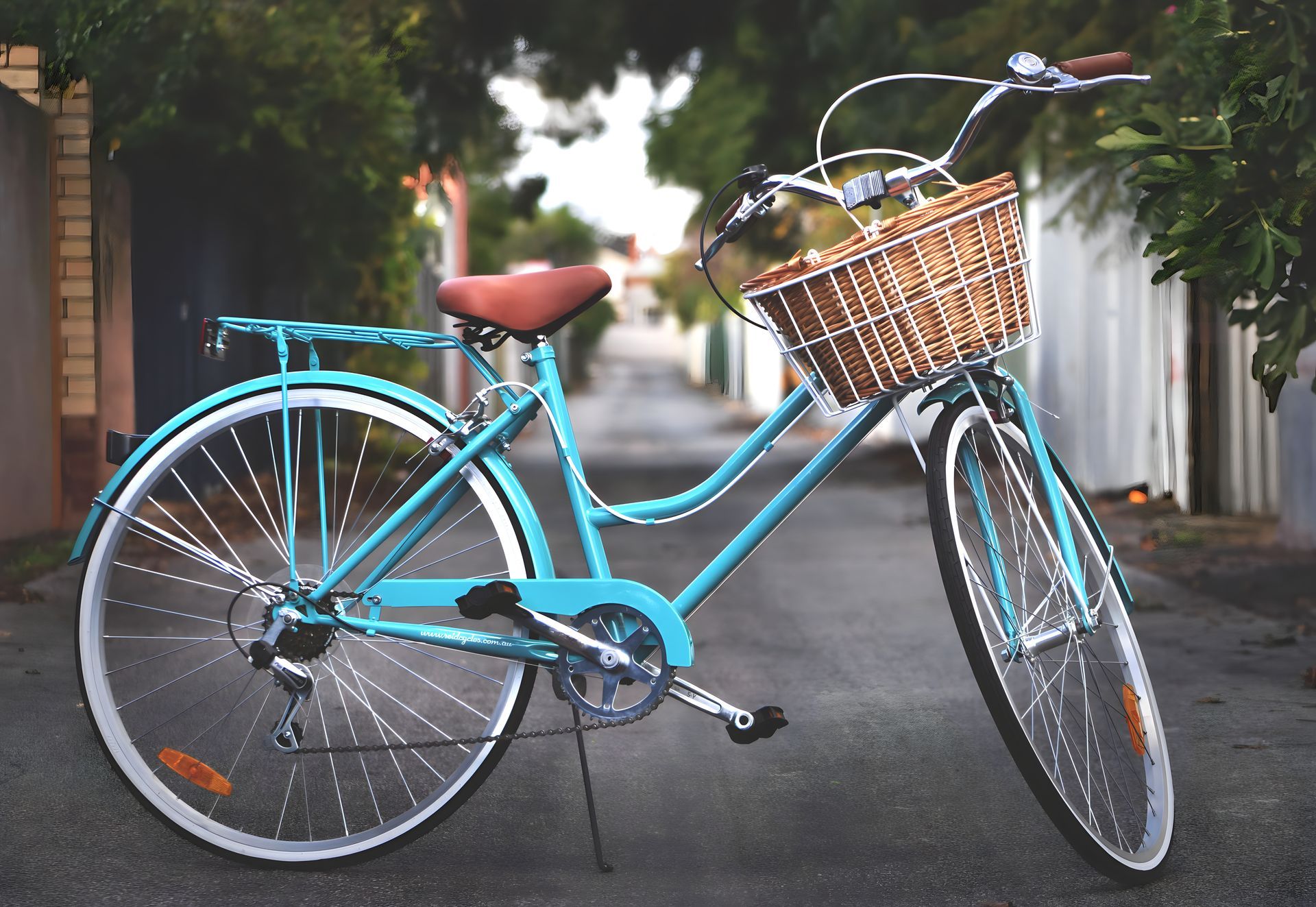 A blue bicycle with a basket on the front is parked on a street
