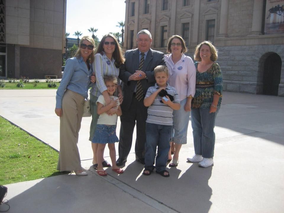 Agency founder Cynthia Macluskie is posing for a picture with a family in front of a court building.