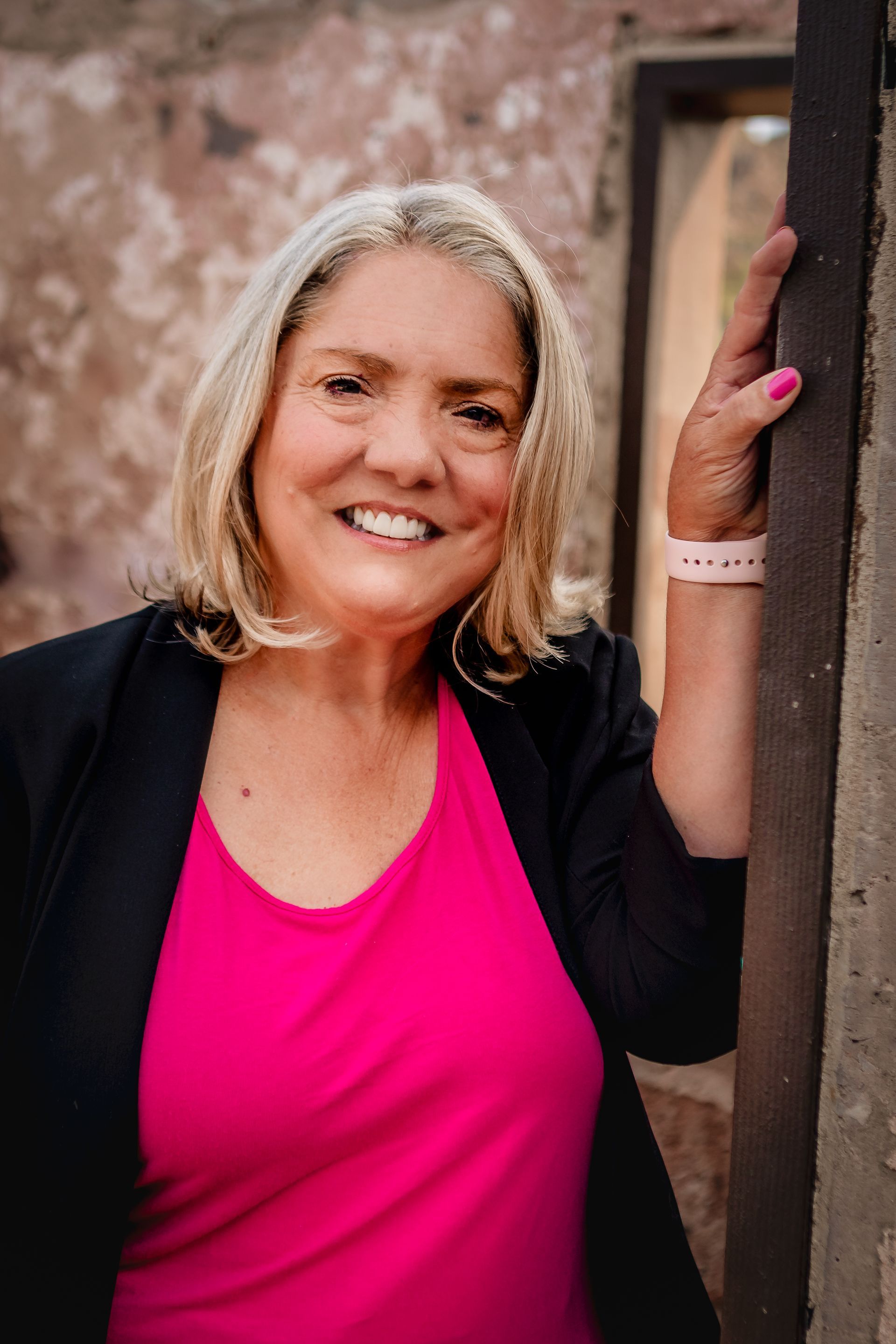 Agency founder Cynthia Macluskie is leaning against a wall and smiling.