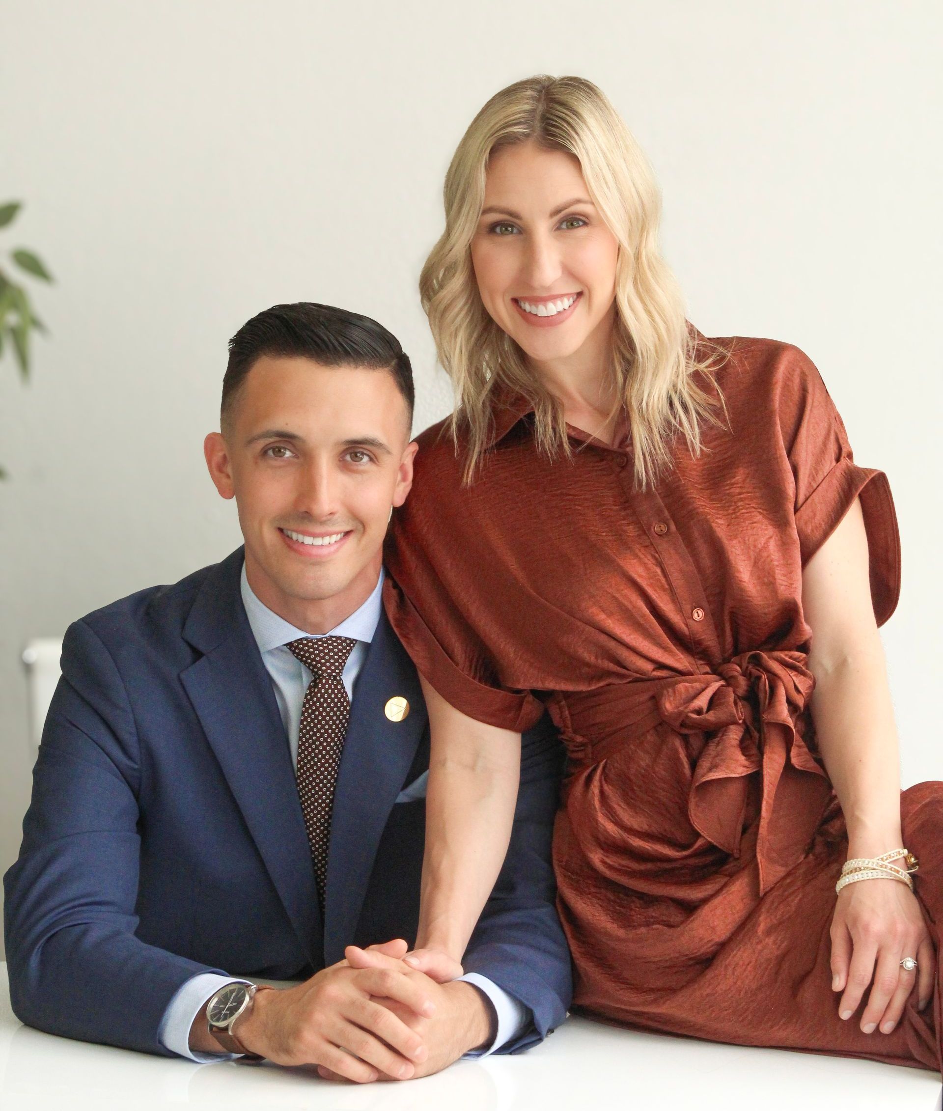 A man and a woman are posing for a picture while sitting at a table.