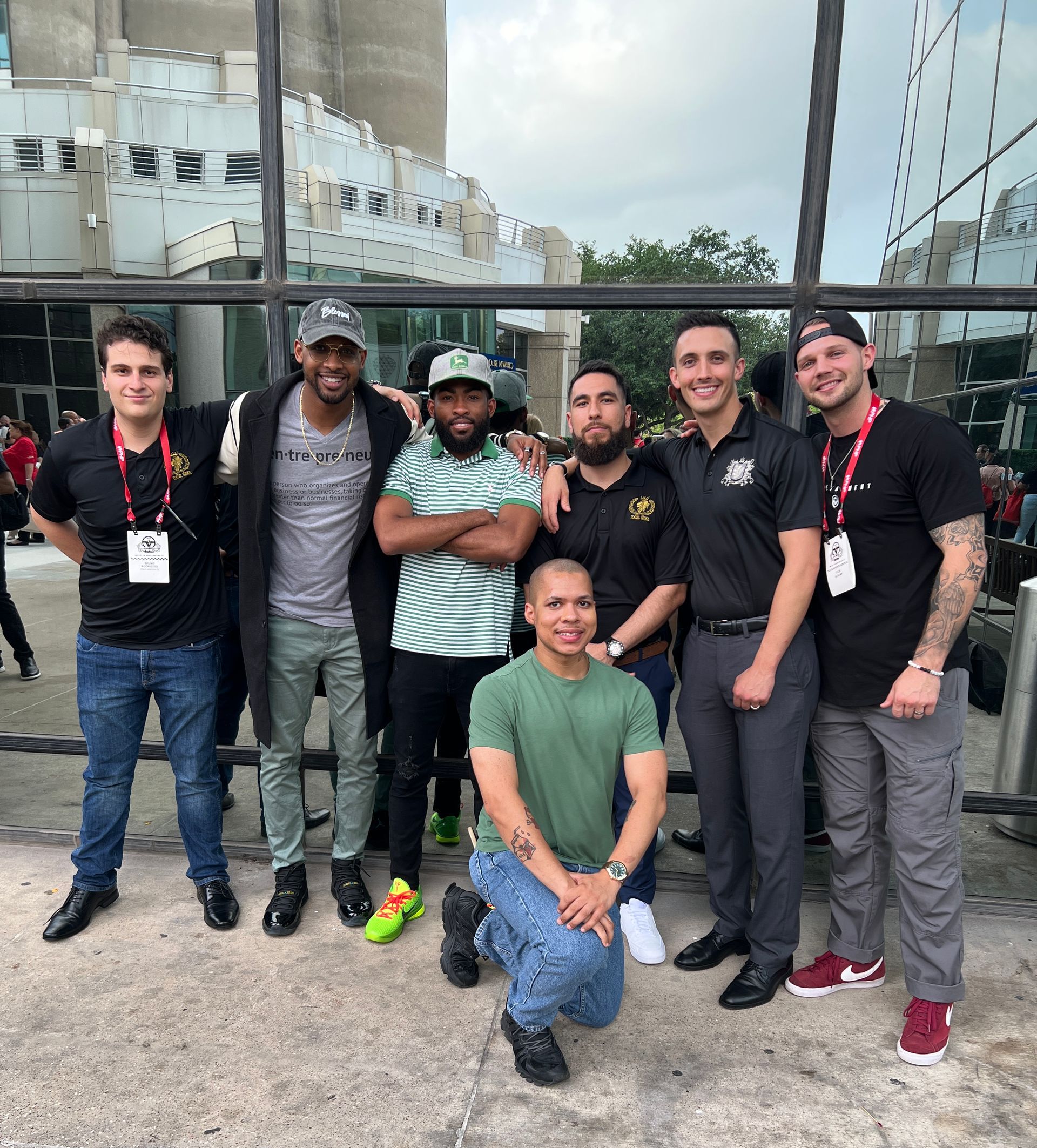 A group of men are posing for a picture in front of a building.