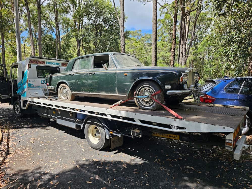 A Car is Sitting on Top of a Flatbed Tow Truck — Optimum Towing in Sanctuary Point, NSW