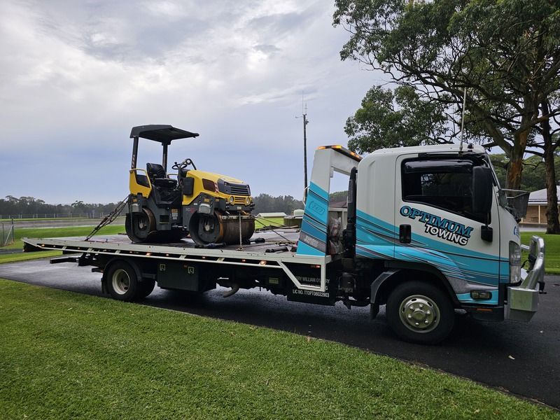A Tow Truck is Carrying a Yellow Roller on the Back of It — Optimum Towing in Nowra, NSW