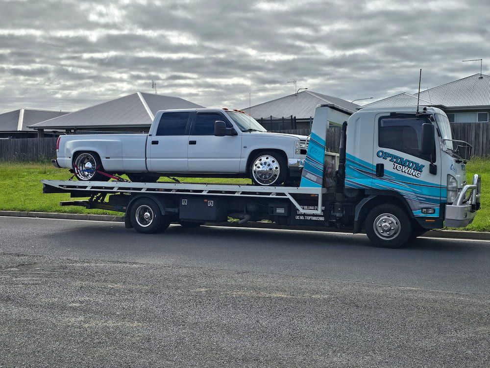 A White Truck is Being Towed by a Tow Truck — Optimum Towing in Gerringong, NSW