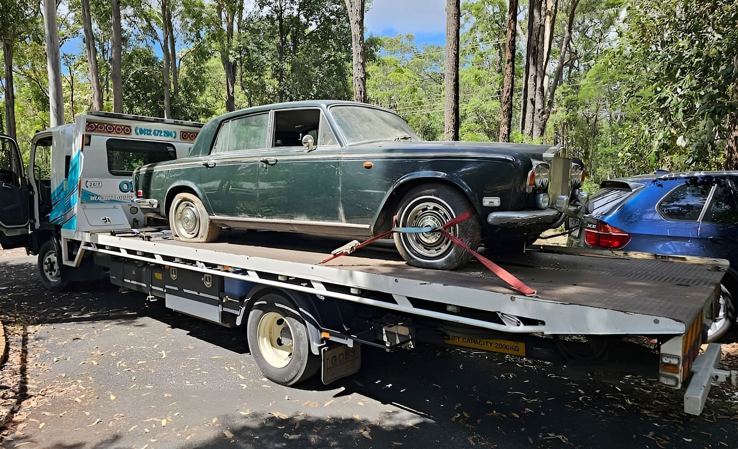 Green Vintage Rolls-Royce Car On A Flatbed Tow Truck Outdoors