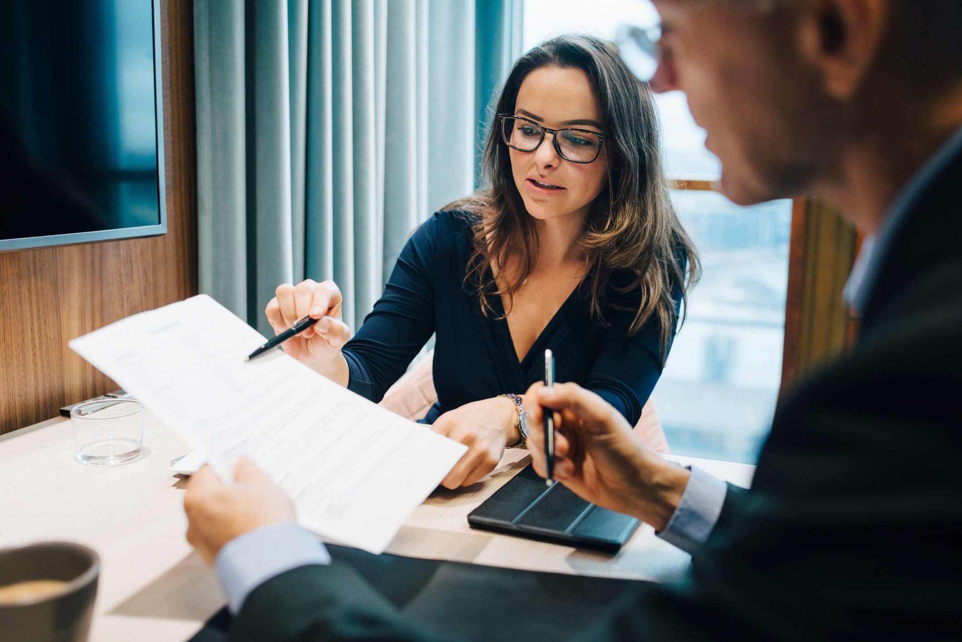 A man and a woman are sitting at a table looking at a piece of paper.