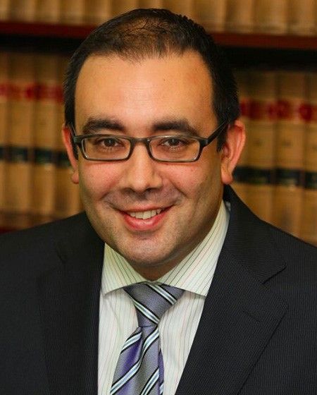 A man in a suit and tie is smiling for the camera