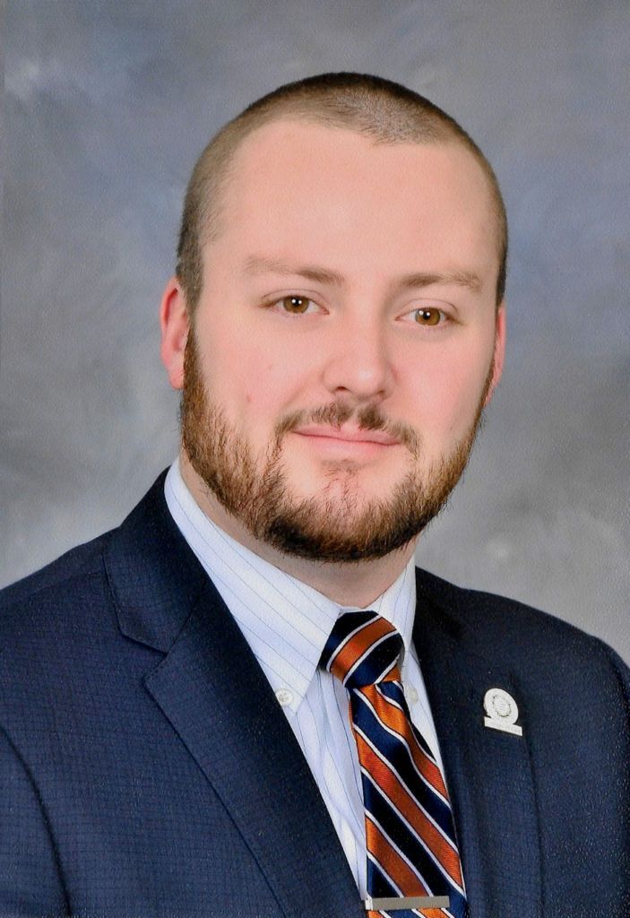 A man with a beard is wearing a suit and tie