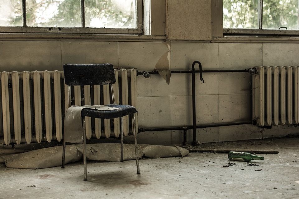 A chair in a room with radiators and a window